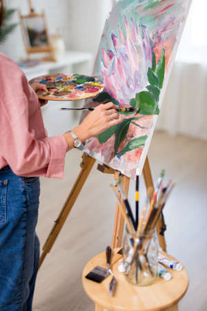 art, creativity and inspiration concept - close up of female hands  painting at home or studio