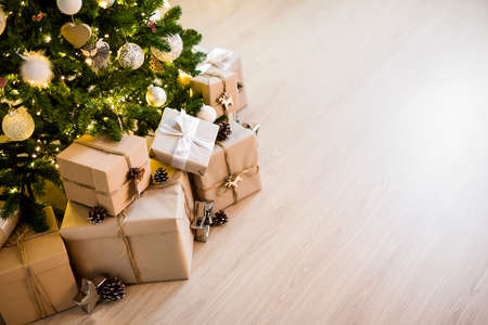 decorated christmas tree and heap of gift boxes - copy space over wooden floor backgroundの写真素材
