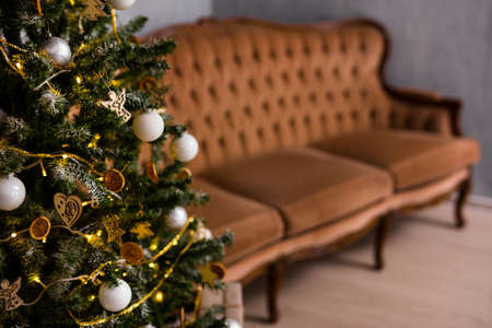 decorated christmas tree and vintage sofa in living roomの写真素材