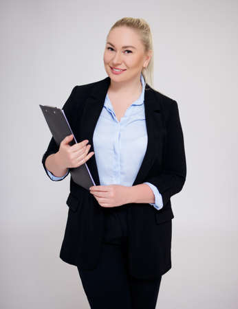 portrait of happy business woman posing over gray backgroundの写真素材
