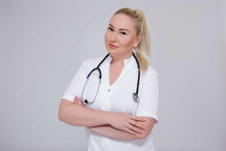 portrait of young female doctor posing over gray backgroundの写真素材