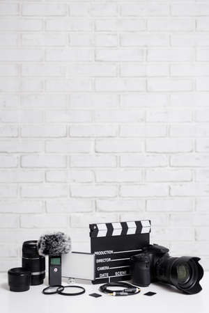 videography concept - modern dslr camera, lenses, microphone, led light, memory cards, clapper board...