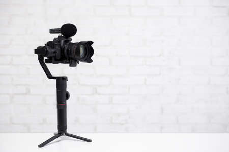 full length portrait of professional videographer with dslr camera on 3-axis gimbal isolated on...
