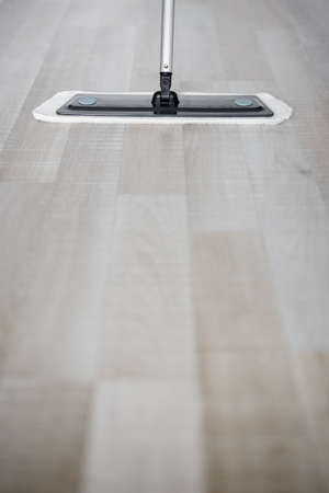 close up of wooden floor with microfiber mop and copy space