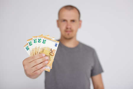 credit, business and finance concept - close up of euro money banknotes in male hands over grey...