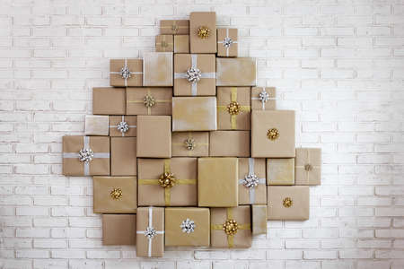 Many wrapped gifts with bows on brick wall background