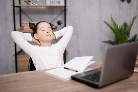school, homework and distance education concept - cute school girl resting after doing homework at...