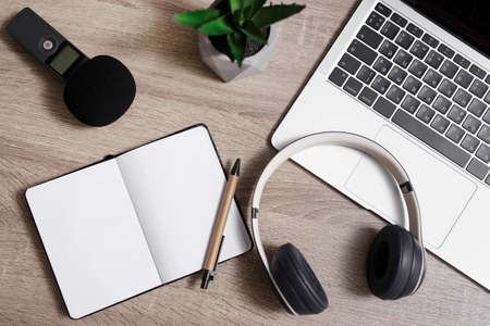 journalism and blogging concept - top view of workplace with laptop, microphone, headphones, notepad...