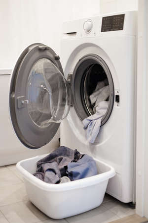 modern washing machine and laundry basket in bathroom
