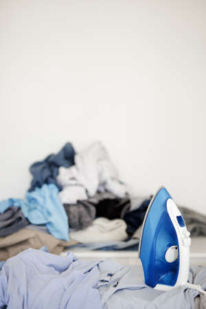 close up of modern iron and wrinkled laundry over white wall background with copy spaceの写真素材
