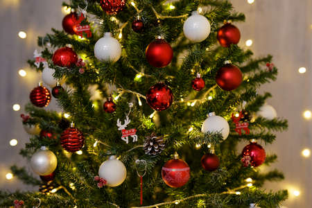 close up of decorated Christmas tree with colorful baubles and festive led lights