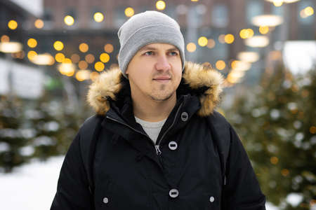 Close up portrait of man in Christmas market decorated with holiday lightsの写真素材