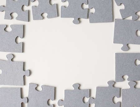 frame of puzzle pieces over white table backgroundの写真素材