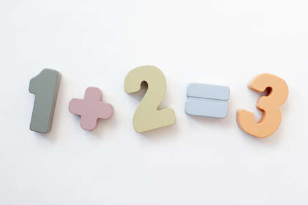 education concept - wooden numbers one plus two equal three over white background