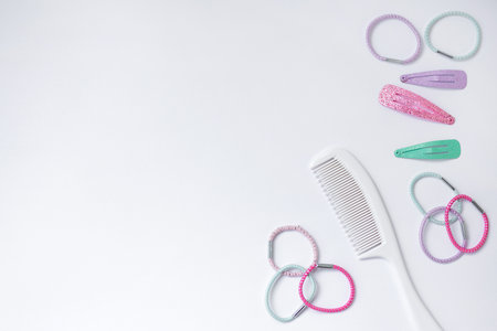 Hair care concept -  little brush and colorful hair scrunchies and hairpins over white background with copy spaceの写真素材