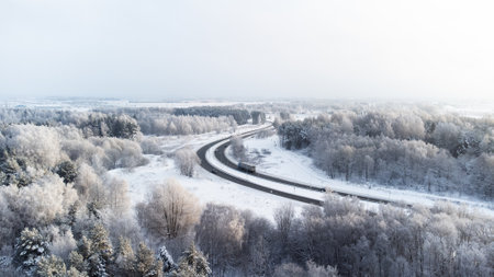 transport and travel concept - aerial view of beautiful winter landscape with roadの写真素材