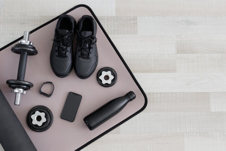 Flat lay of dumbbells, shoes, water bottle, watch and phone on sport mat with copy spaceの写真素材