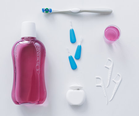Flatlay of dental floss, toothbrush, toothpicks and rinse on white backgroundの写真素材