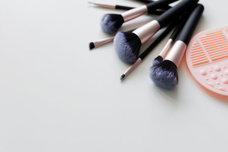 make up brushes and silicone cleaner over white background with copy spaceの写真素材