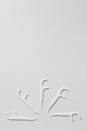 Many white dental toothpicks with dental floss on white background with copyspaceの写真素材