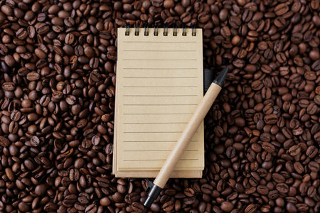 Brown notebook with pen on background from coffee beansの写真素材