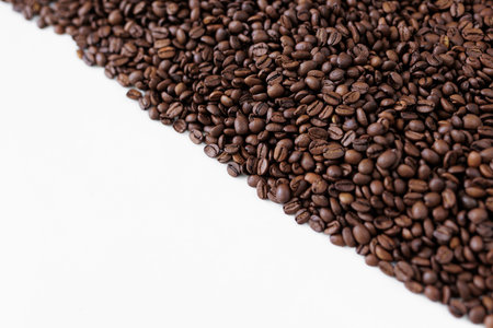 Roasted black coffee beans on white background with copy space