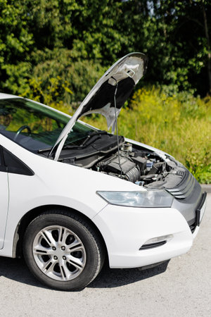Close up of white car with open hood in forestの写真素材