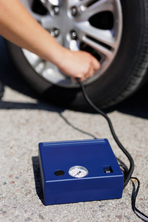 Close up of man checking air pressure and filling air in the tires of carの写真素材
