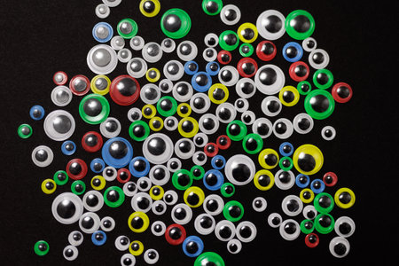 Various sizes and color of funny kids art googly eyes on black backgroundの写真素材