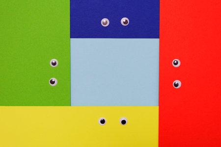 Googly eyes on green, yellow, blue and red backgrounds with frameの写真素材