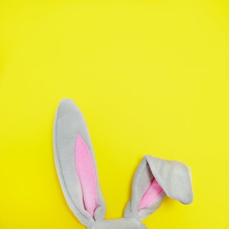 Furry rabbit ears for Easter on a yellow background with copy spaceの写真素材
