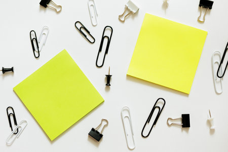 two sticky notes and paperclips over white backgroundの写真素材