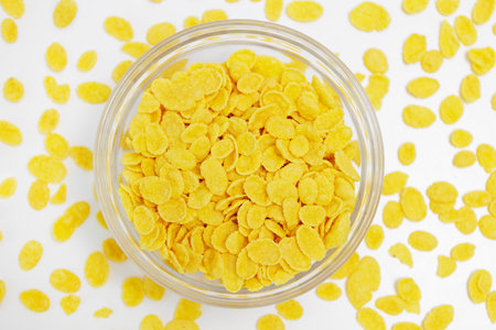 Top view of corn flakes served in glass bowl on whiteの写真素材