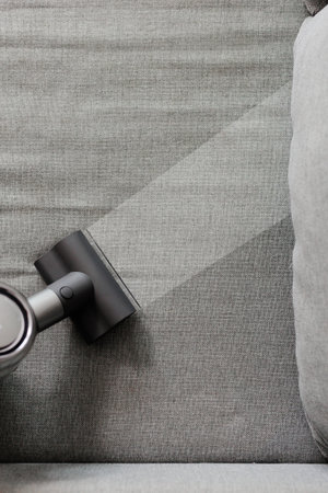top view of modern vacuum cleaner cleaning sofa - before and after conceptの写真素材
