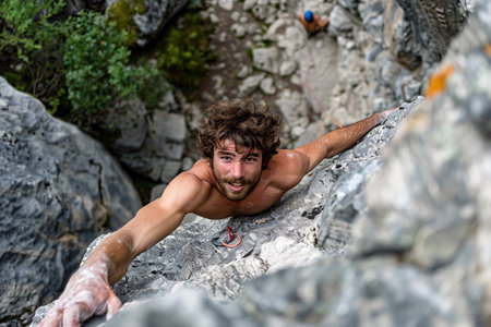 top view of young man climbing on the rockの素材