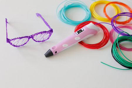 3d pen, kit of colourful plastic filament  and glasses on white background with copyspaceの写真素材