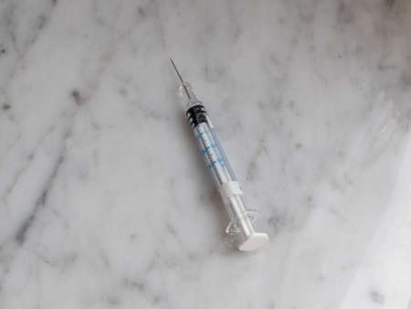 Open syringe, resting on a marble table.の写真素材