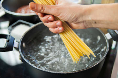 Cooking spaghetti in a pot with boiling waterの写真素材