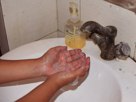 A Indian child washing hand with hand wash or soap to prevent the spread of Corona Virusのeditorial素材