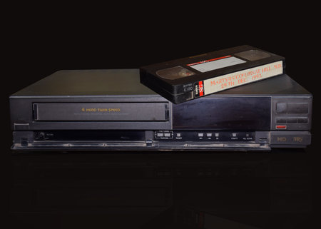 Vintage Old Video Cassette Recorder or VCR with a Video Tape isolated on a black backgroundのeditorial素材