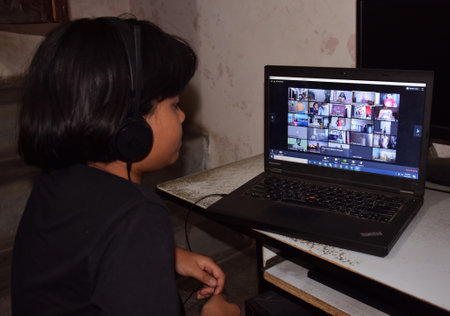 An Indian child focussing  on her school's online classes during Corona Virus Lockdown
