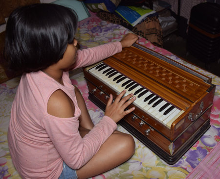 An indian child playing musical instrument Harmoniumのeditorial素材