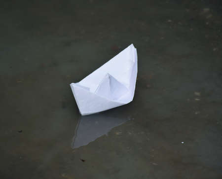 A paper boat floating or sailing in waterの写真素材