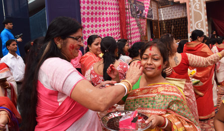 Indian Bengali women playing or applying Vermilion to each other during Durga Puja a ritual known as Sindoor Khela or sindur khela in Bengali Languageのeditorial素材