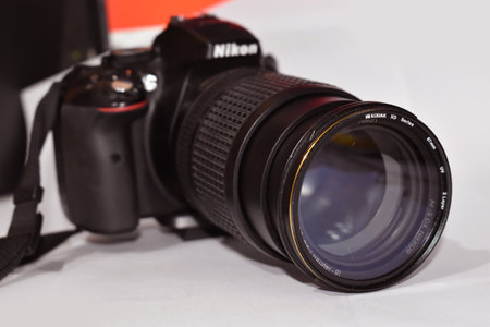Side angle shot of Nikon DSLR or digital Camera with zoom lens in focus. Blurred Camera Bodyのeditorial素材