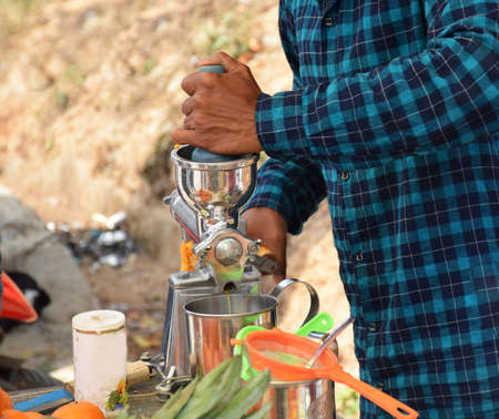 A juice maker preparing orange juice for his customersの写真素材