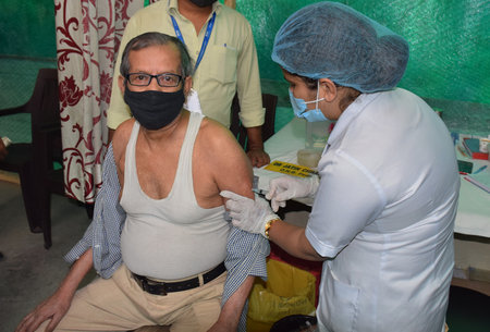 A medical staff inoculates a senior citizen with a Covid-19 coronavirus vaccine at a vaccination centerのeditorial素材