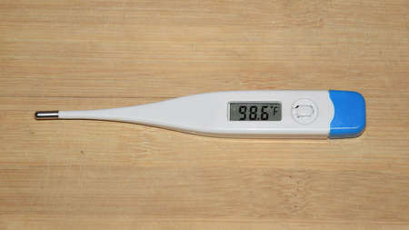 Digital thermometer showing normal reading of human body temperatureの写真素材