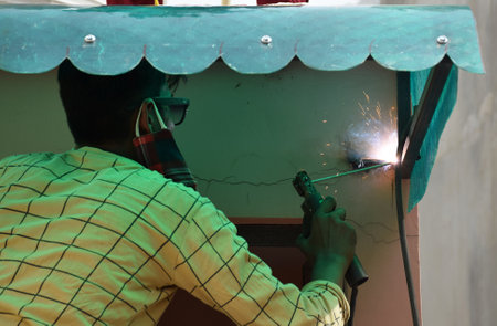 Indian technician or worker welding an Iron shade Grillのeditorial素材