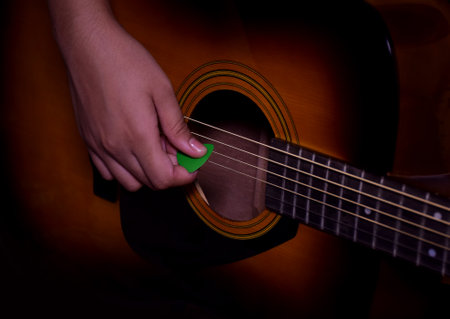 Close up of a hand strumming or playing a guitarの写真素材